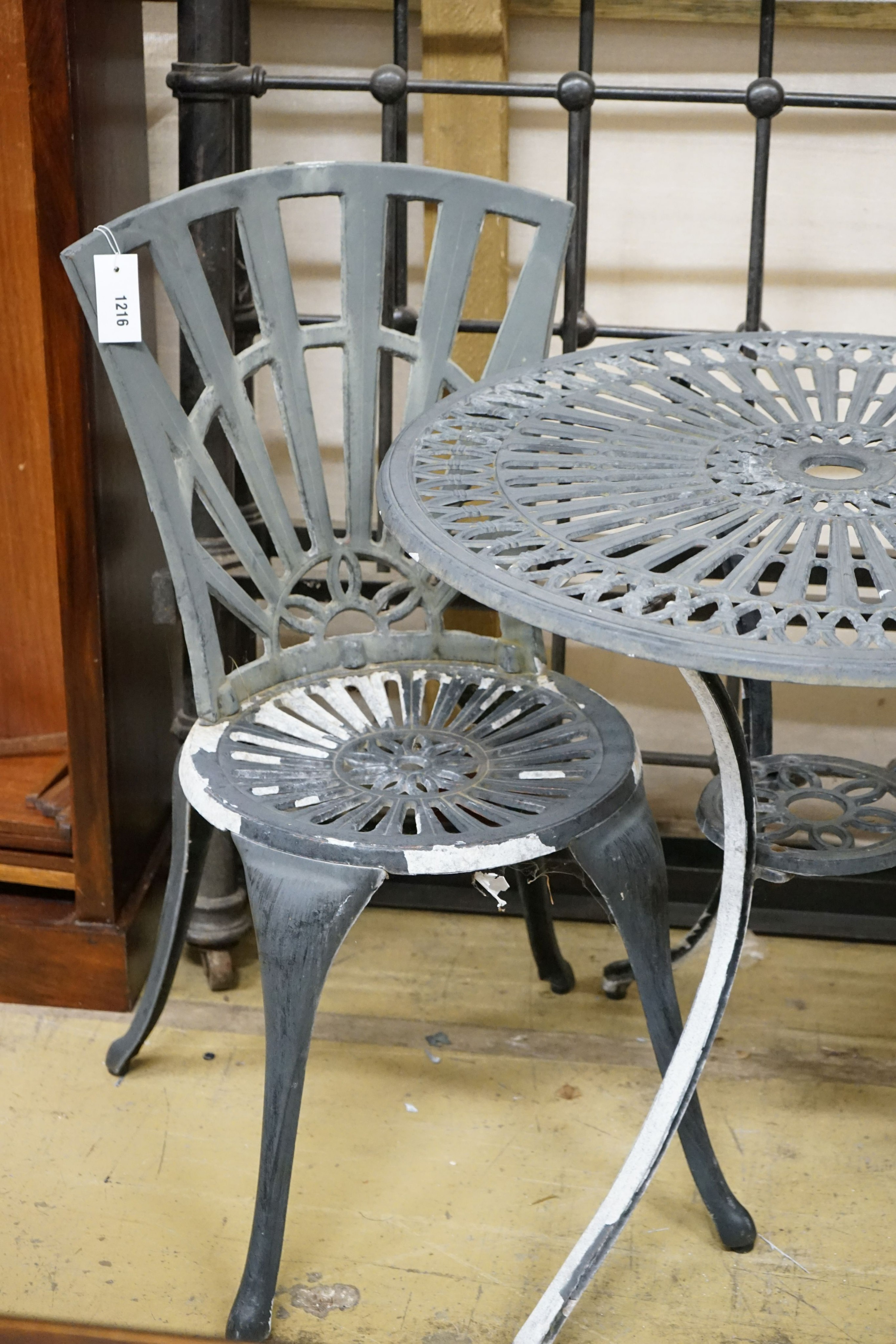 A painted aluminium circular garden table, diameter 69cm, height 66cm and two chairs